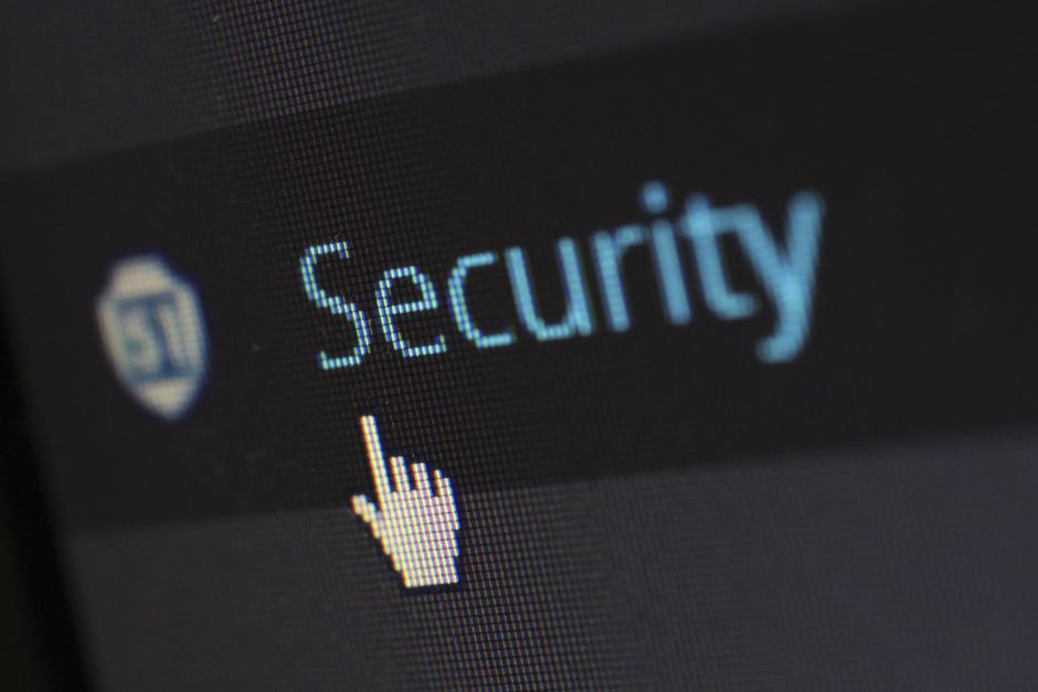 The word "security" in blue shows up on a computer screen with a black backround. A while hand hovers over the word as someone gets ready to click on it.